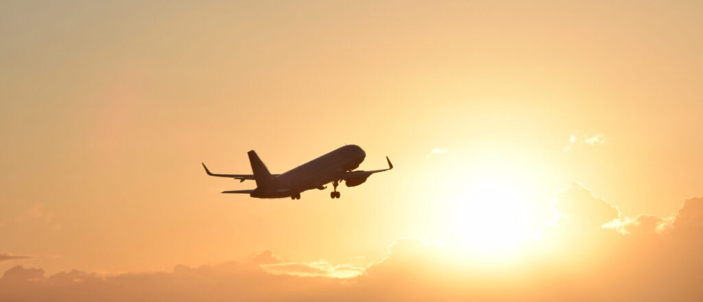 Avion comercial volando al atardecer para viajes organizados y circuitos por el mundo con Traveland