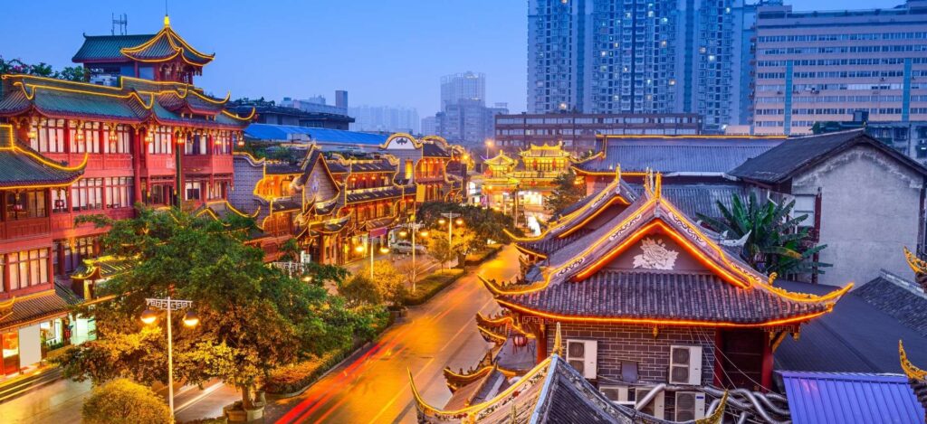 Tejados tradicionales iluminados y rascacielos al anochecer en Chengdu, durante la etapa del circuito China con Panda de Traveland.