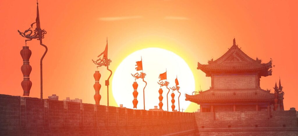 Silueta de la antigua muralla de Xi'an con farolillos tradicionales durante un gran atardecer, parada incluida en el circuito China con Panda de Traveland.
