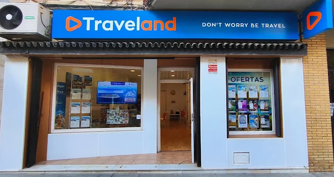 Fachada exterior de la oficina física de la agencia de viajes Traveland con escaparates de ofertas