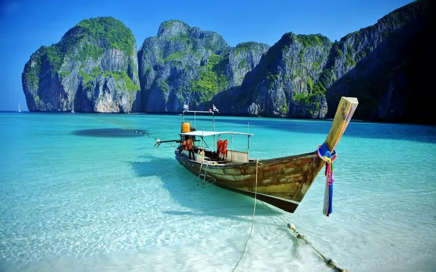 Barco tradicional long-tail en las aguas cristalinas de Maya Bay en las islas Phi Phi Tailandia con Traveland