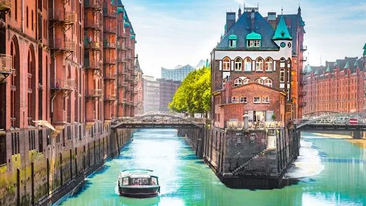 Distrito Speicherstadt con barco navegando por los canales en Hamburgo Alemania con Traveland