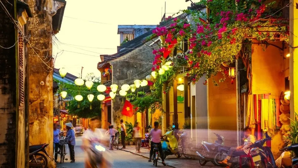 Calle pintoresca del casco antiguo de Hoi An adornada con farolillos tradicionales y fachadas amarillas en Vietnam con Traveland