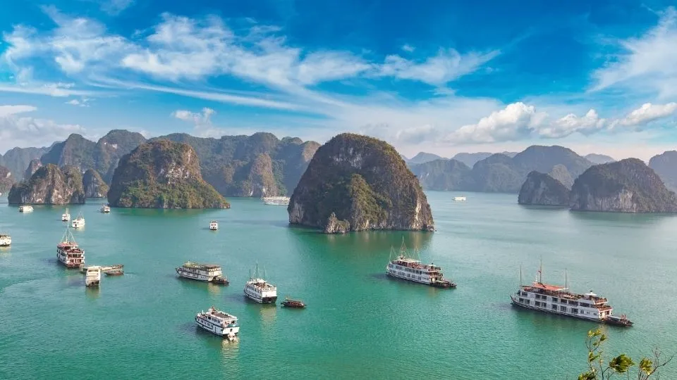Cruceros turísticos navegando entre gigantescas islas de piedra caliza en la bahía de Ha Long Vietnam con Traveland