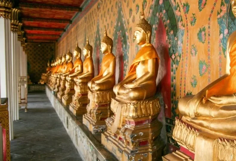 Hilera de estatuas doradas de Buda en el claustro de un templo en Bangkok Tailandia con Traveland