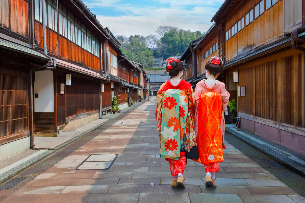 Dos geishas paseando con kimono tradicional por la calle de madera de Higashi Chaya en Kanazawa Japón con Traveland