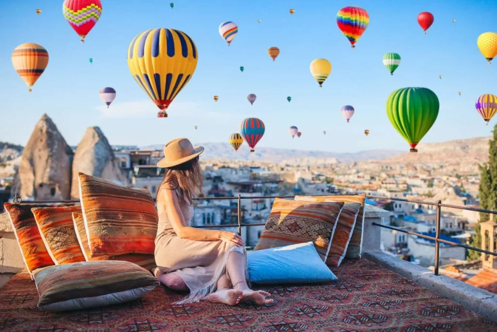 Capadocia Magica. Mujer observando los globos aerostáticos desde una terraza en Capadocia Turquía con Traveland