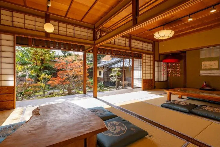 Interior de habitación tradicional ryokan con tatami y vistas a un jardín japonés con Traveland