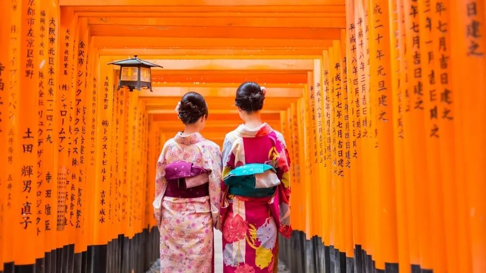 Mujeres con kimono tradicional paseando entre los torii rojos de Fushimi Inari en Kioto Japón con Traveland