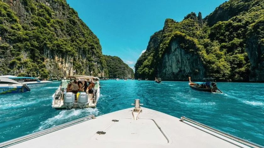 Navegación en lancha sobre aguas turquesas entre acantilados en las islas Phi Phi Tailandia con Traveland