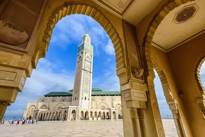 Vista de la Mezquita Hassan II y su gran minarete enmarcada desde los arcos de piedra en Casablanca Marruecos con Traveland