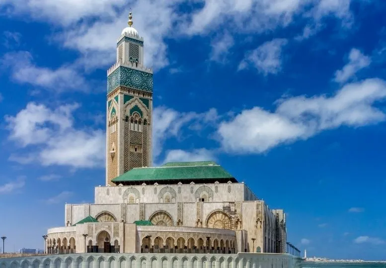 Vista completa de la gran Mezquita Hassan II y su alto minarete junto al oceano Atlantico en Casablanca Marruecos con Traveland