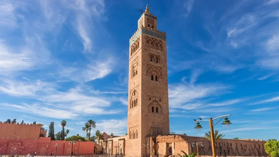 Minarete de la mezquita Koutoubia erigiendose bajo un cielo azul en Marrakech Marruecos con Traveland
