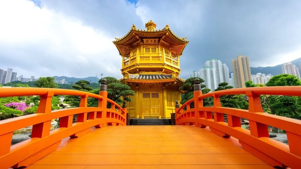 Pabellón dorado con puente rojo en los jardines Nan Lian de Hong Kong con Traveland