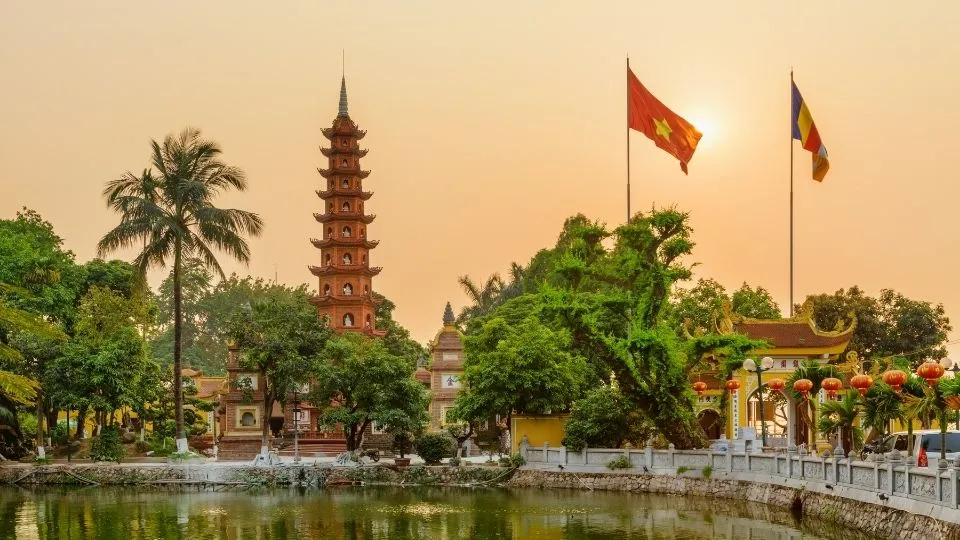 Pagoda rojiza Tran Quoc con la bandera de Vietnam a orillas del Lago del Oeste al atardecer en Hanoi con Traveland