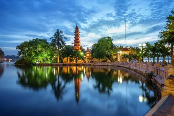 Vista panorámica nocturna de la pagoda iluminada Tran Quoc y su reflejo en el Lago del Oeste en Hanoi Vietnam con Traveland