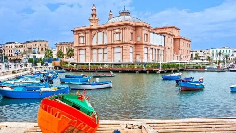 Teatro Margherita de estilo Art Nouveau frente a barcas pesqueras en el puerto de Bari Puglia Italia con Traveland