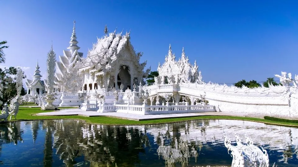 Fachada blanca y reflejo del templo Wat Rong Khun en Chiang Rai Tailandia con Traveland