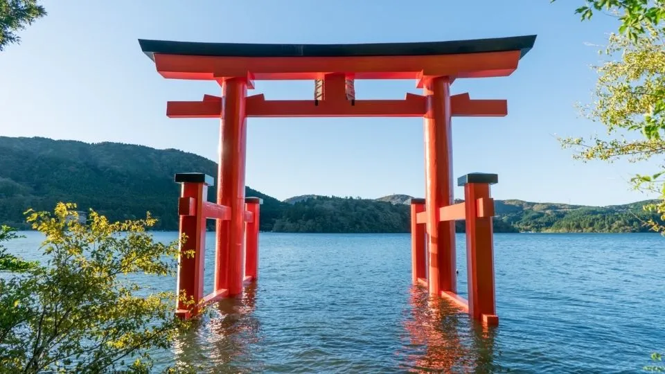 Gran puerta torii roja sobre el agua del lago Ashi en el santuario de Hakone Japón con Traveland
