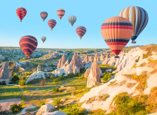 Globos aerostáticos sobrevolando las chimeneas de hadas en Capadocia Turquía con Traveland
